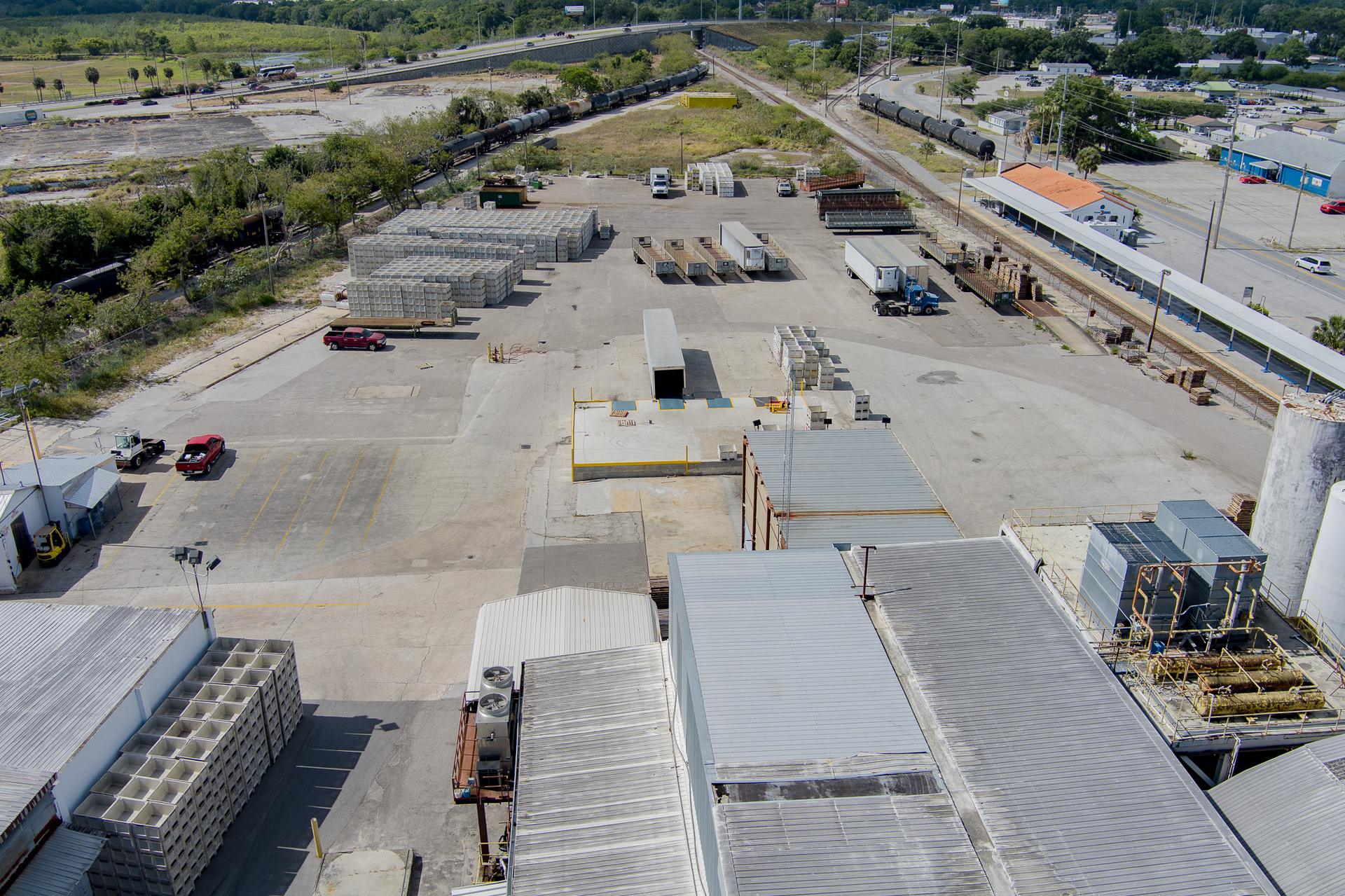 Aerial view of the secured EZ Truck Parking yard in Winter Haven, Florida — trucks, trailers and a wide paved lot off the interstate.
