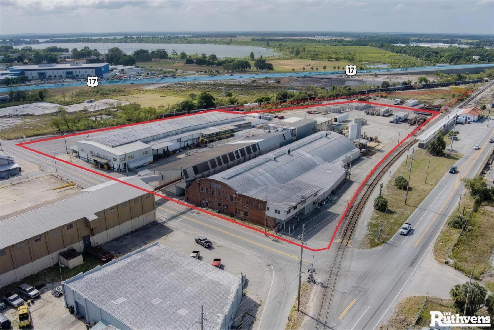 Aerial view of the secured, fenced EZ Truck Parking yard in Winter Haven, Florida with wide paved rows for RVs and boats.
